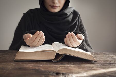 Muslim woman reading holy islamic book koranの写真素材