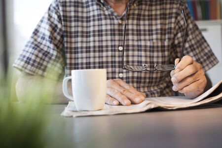 Man reading newspaper on tableの写真素材