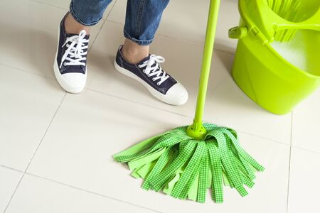 Woman with cleaning supplies in home