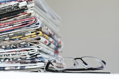 Newspapers with eyeglasses on white background