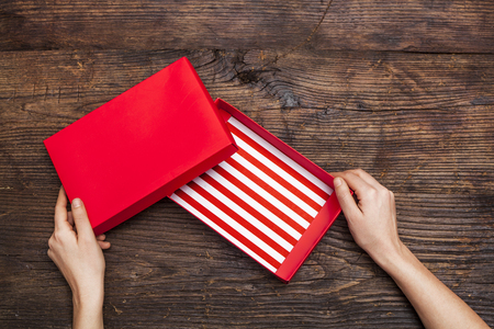 Woman hands holding empty gift box on wooden backgroundの写真素材