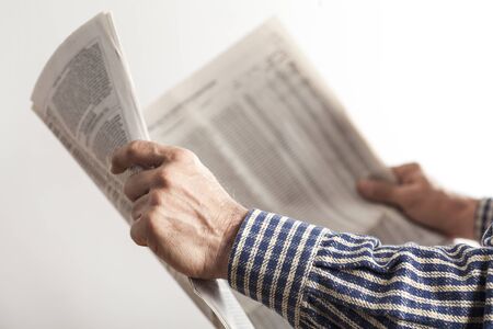 Man reading newspaper on gray backgroundの写真素材