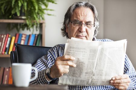 Senior man reading newspaperの写真素材