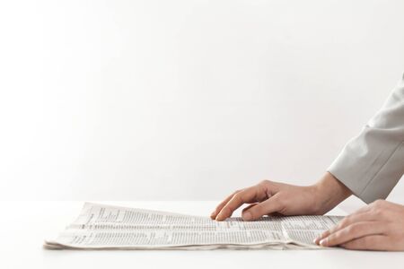 Woman hand reading newspapers on tableの写真素材