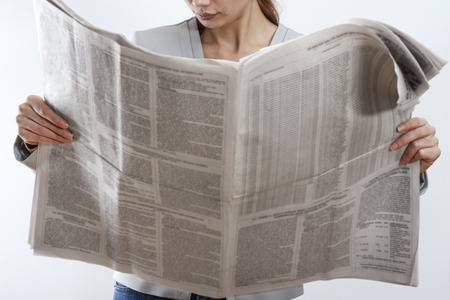 Woman reading newspaper on white backgroundの写真素材