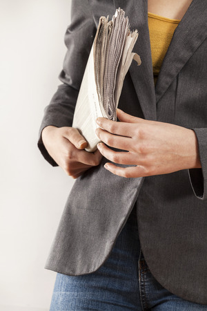 Woman holding newspaper on white backgroundの写真素材