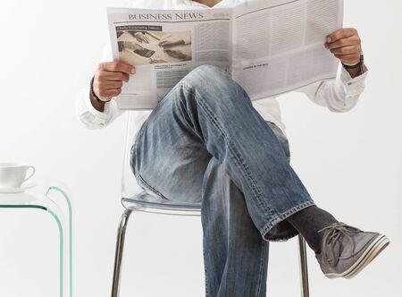 Sitting man reading newspaperの写真素材