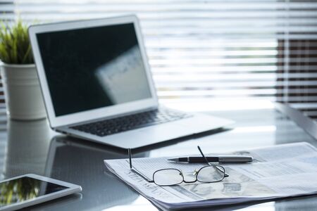 Newspaper and computer on tableの写真素材