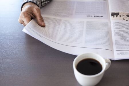 Man reading newspaper on tableの写真素材