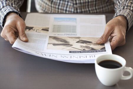 Man reading newspaper on tableの写真素材