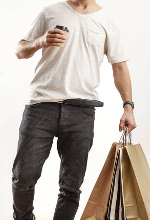 Man holding paper shopping bag on gray backgroundの写真素材