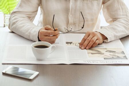 Man reading newspaper on table
