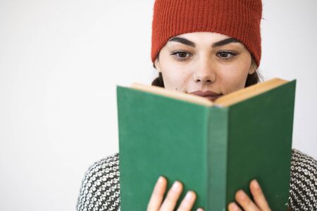Young woman reading book on gray backgroundの写真素材
