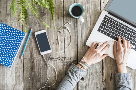 Woman hands using laptop on wooden tableの写真素材