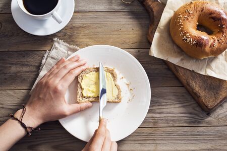 Woman hand spreading butter on sliced breadの写真素材
