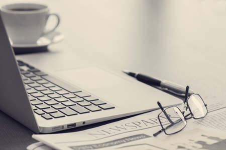 Newspaper with computer on tableの写真素材