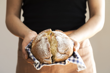 Female hand holding hot freshly baked bread