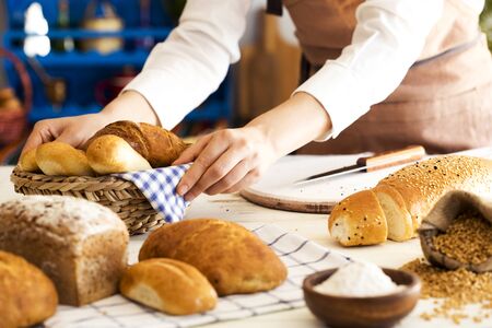 Female hands holding freshly bread in basketの写真素材