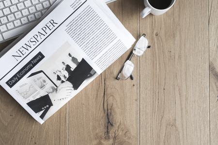 Newspaper with keyboard on tableの写真素材