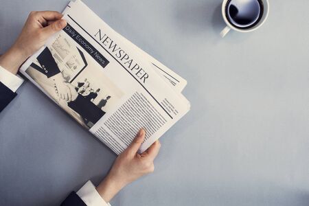 Reading newspaper on deskの写真素材