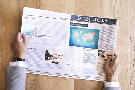 Man reading newspaper on tableの写真素材