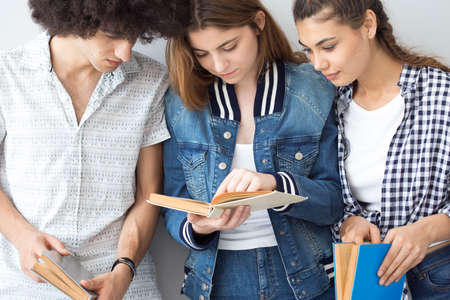 Young people looking at a bookの写真素材