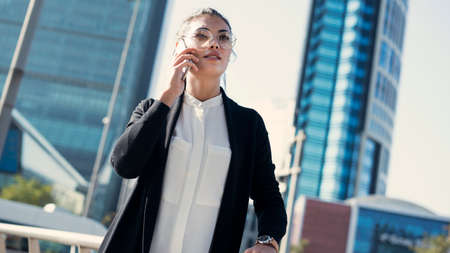 Businesswoman talking mobile phone in the outdoorsの写真素材