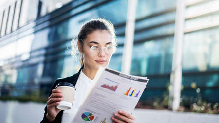 Businesswoman hand coffee with document in outdoorsの写真素材