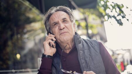 Senior man talking phone in outdoorsの写真素材