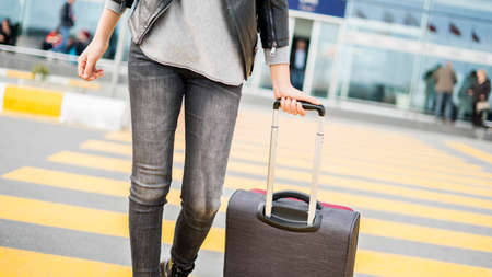 Passenger walking  at the airport with suitcaseの写真素材