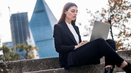 Young woman using laptop in outdoorsの写真素材