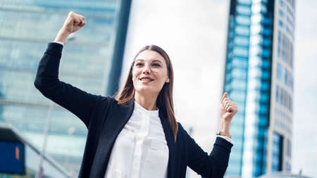 Successful business woman with arms up outdoorsの写真素材