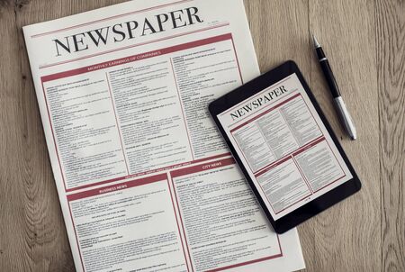 Newspaper with digital tablet on wooden backgroundの写真素材