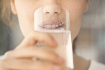 Young woman drinking water close up view