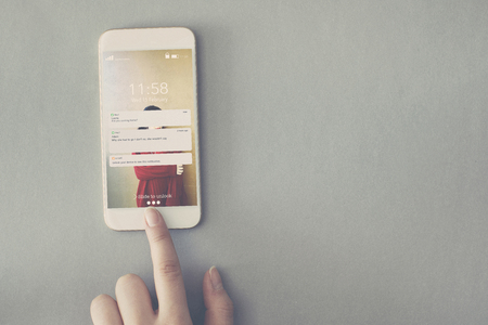 Mobile phone with message pointing fingerの写真素材