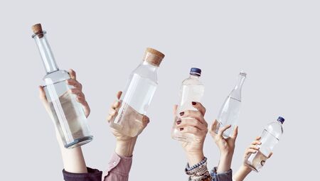 Different people holding water bottlesの写真素材