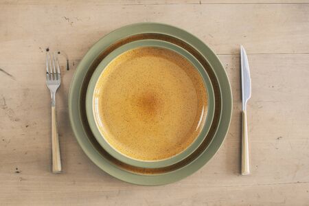 Empty plates knife fork on wooden backgroundの写真素材