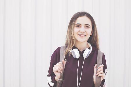 Portrait of student girl with backpack and earphoneの写真素材