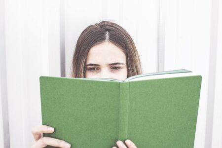 Young woman reading book outsideの写真素材