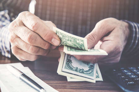 Man holding and counting moneyの写真素材