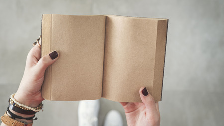 Woman holding open empty pages notebookの写真素材