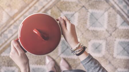 Young woman holding red saucepanの写真素材