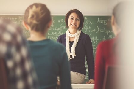 Teacher giving lesson to students in  classroomの写真素材