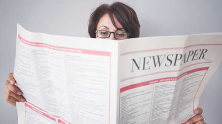 Woman reading the newspaper on wall