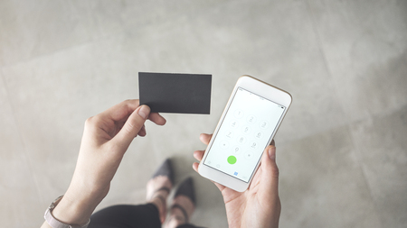 Business woman holding business card and mobile phoneの写真素材