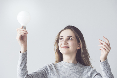 Woman holding a light bulbの写真素材