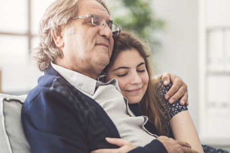Young daughter hugs her fatherの写真素材