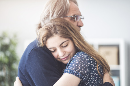Young daughter hugs her fatherの写真素材