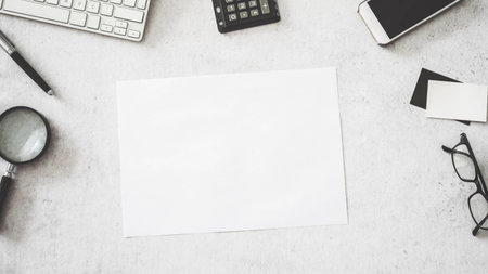 Blank white paper with office suppliesの写真素材