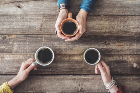 People hands holding a cup of coffeeの写真素材